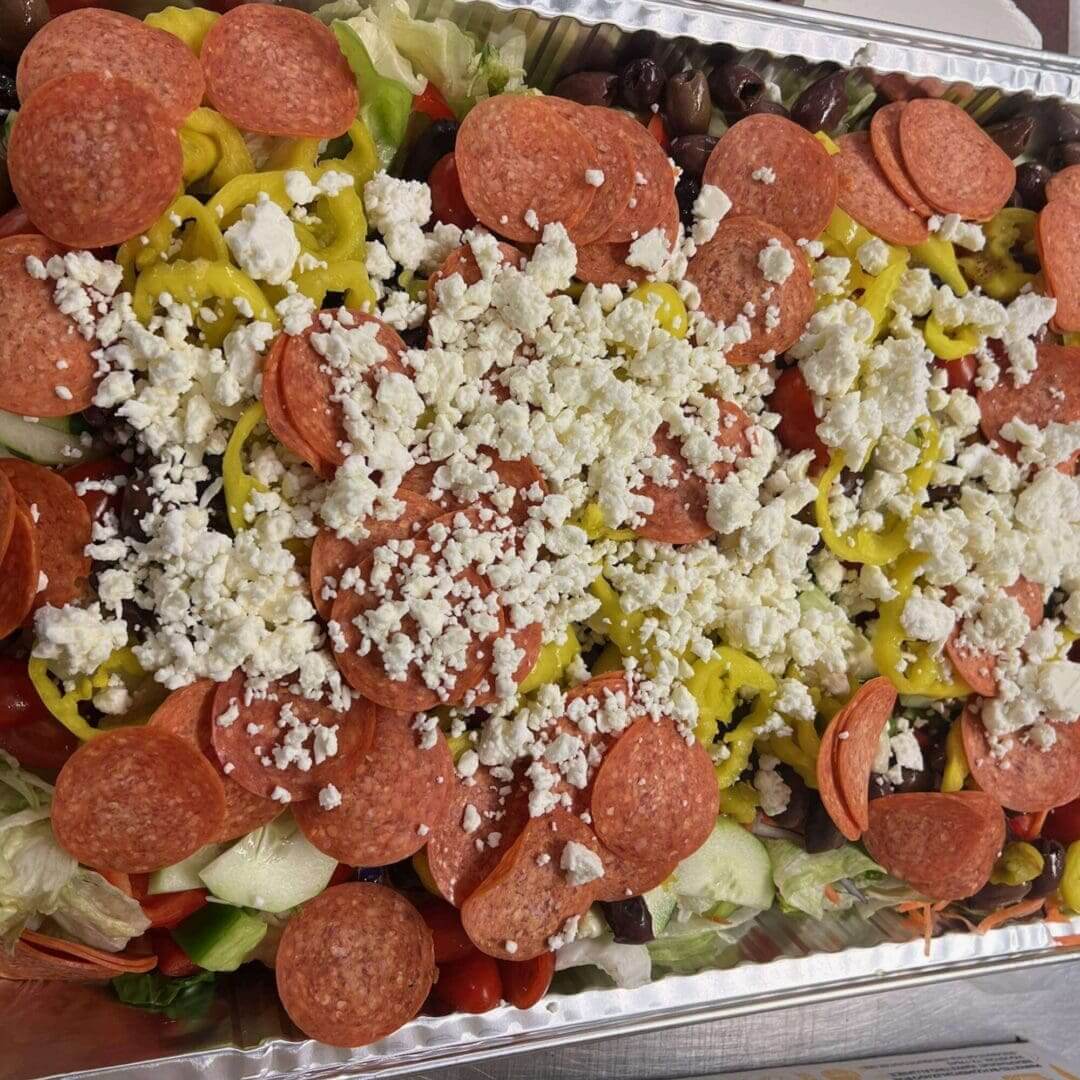 A tray of food with pepperoni, cheese and other toppings.