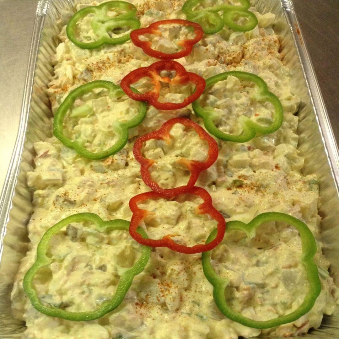 A tray of food with peppers on top.